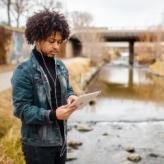 Online student studying outdoors