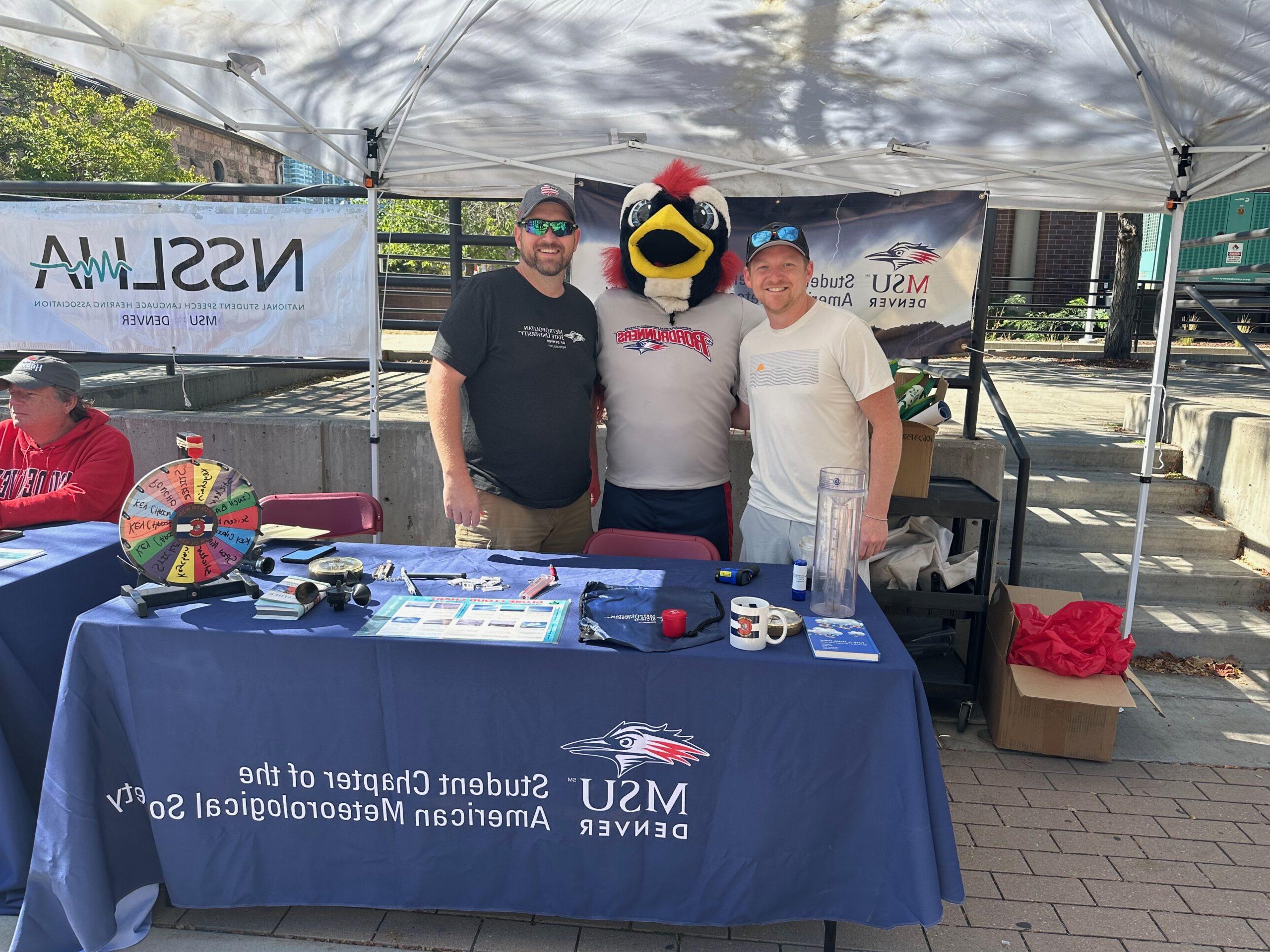 Students posing with Rowdy the roadrunner at the student chapter of the American meteorological society booth