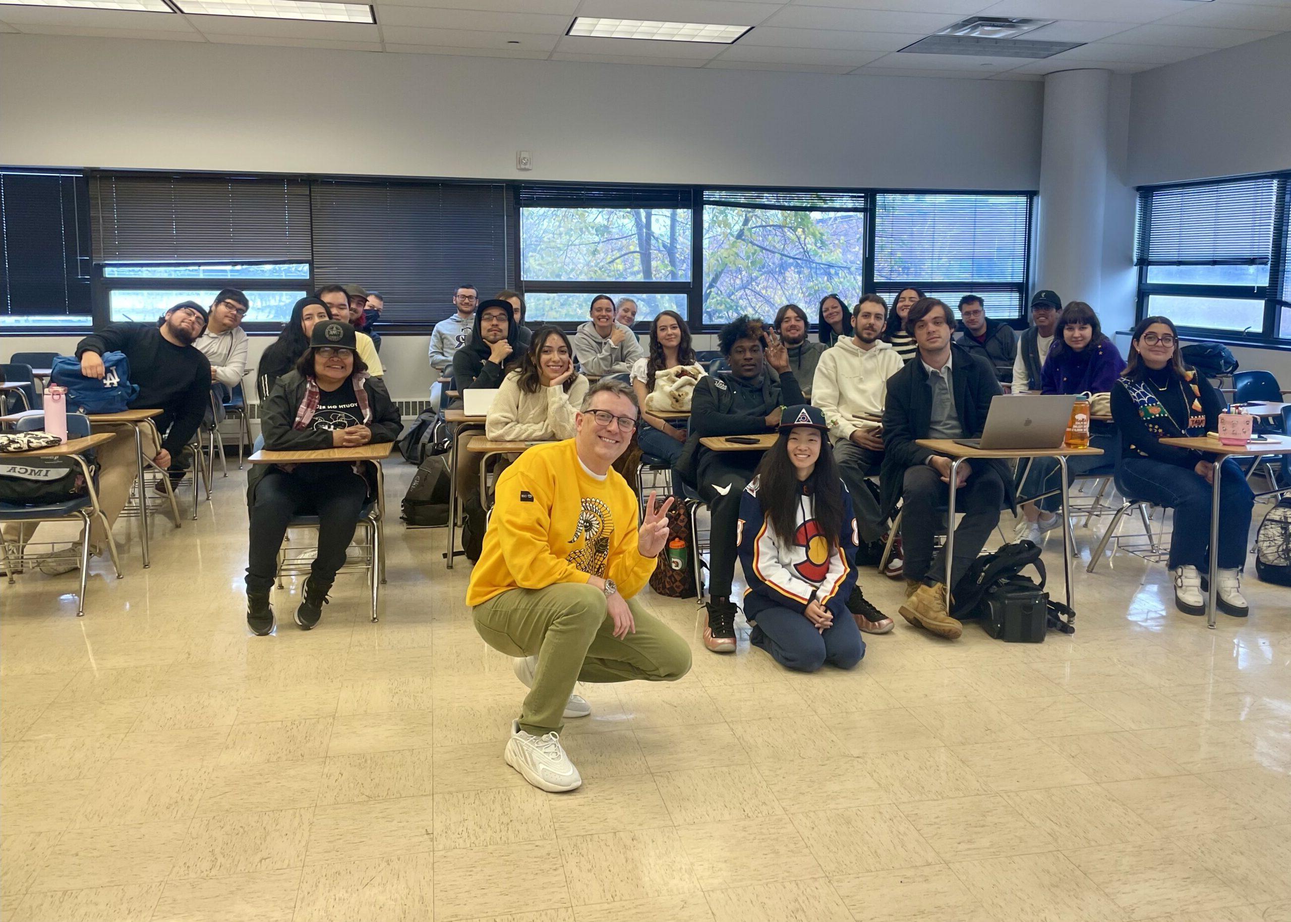 Students in Public Relations Fundaments class smile with a class visitor